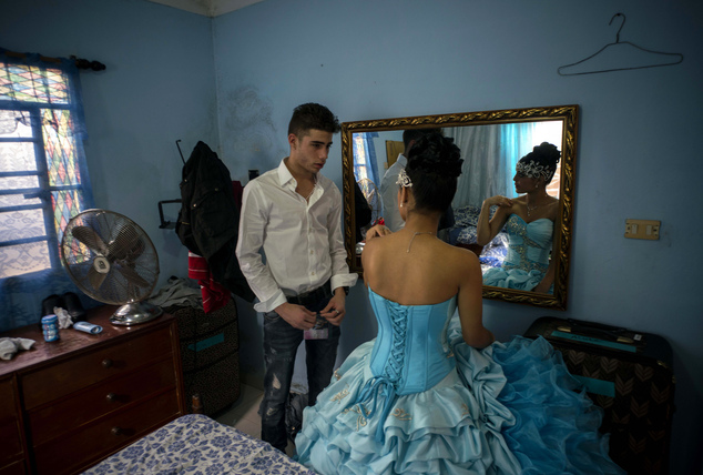 In this Dec. 20, 2015 photo, Daniela Santos Torres, 15, speaks with her boyfriend Erick before her quinceanera party in the town of Punta Brava near Havana, Cuba. Daniela left Cuba when she was 3, returning in December for her quinceanera photos and party. She now lives in Glendale, Arizona, where her father runs a home remodeling business. She said returning to Cuba for her celebration was "a dream," allowing her to include her extended family and friends on the island. (AP Photo/Ramon Espinosa)