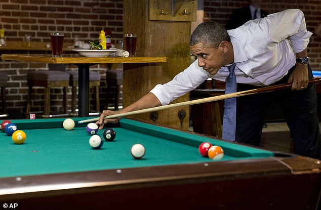 President Barack Obama plays pool at Wynkoop Brewing Co. with Colorado Gov. John Hickenlooper, not seen, Tuesday, July 8, 2014, in Denver. (AP Photo/Jacquelyn Martin)