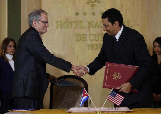 Jeffrey DeLaurentis, U.S. Charge d'Affaires in Cuba (L), shakes hands with Cuban Deputy Transportation Minister Eduardo Rodriguez Davila after signing accords to join forces to prevent, contain and cleanup oil spills in their respective Gulf of Mexico waters, in Havana, Cuba, January 9, 2017. REUTERS/Alexandre Meneghini