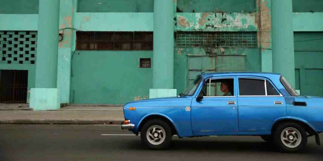 Cuban drivers of state-owned cars have to take people at bus stops
