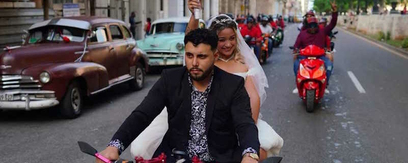 Procesión nupcial en vehículos de dos ruedas de una pareja cubana